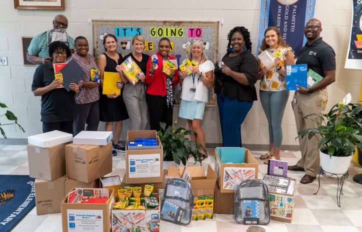 group of people volunteering alongside stationery donations